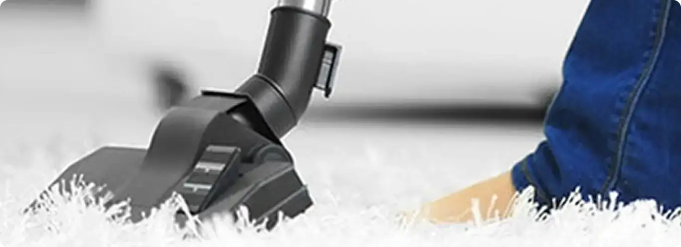 Close-up of a professional vacuuming a white carpet in Elgin.